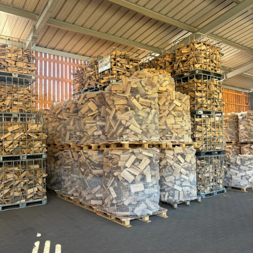 Palettes de bûches stockées sous un hangar